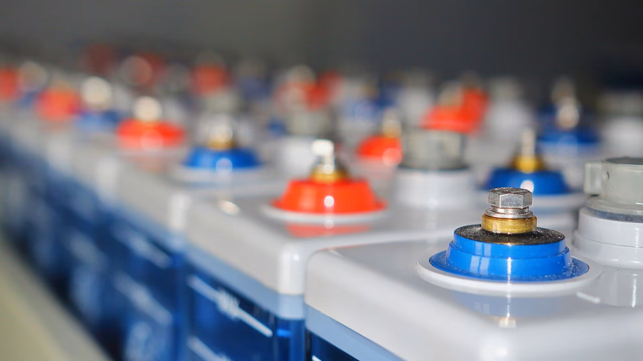 Rows of stationary battery cells with red and blue terminal caps