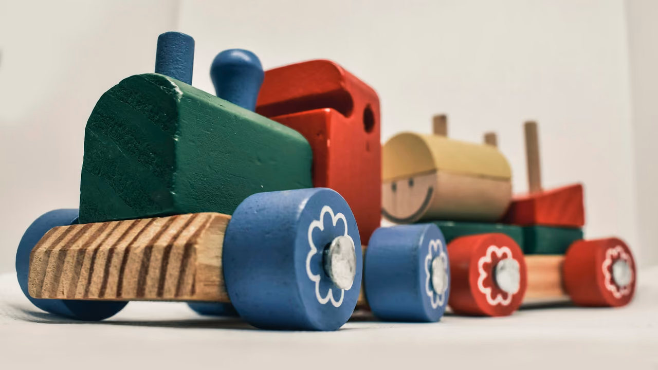 Painted wooden toy train with a locomotive and a wagon